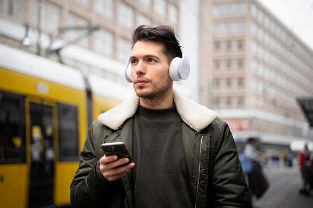 Hombre de tiro medio usando audífonos