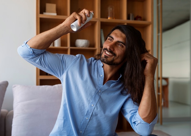 Foto gratuita hombre de tiro medio usando champú seco en casa