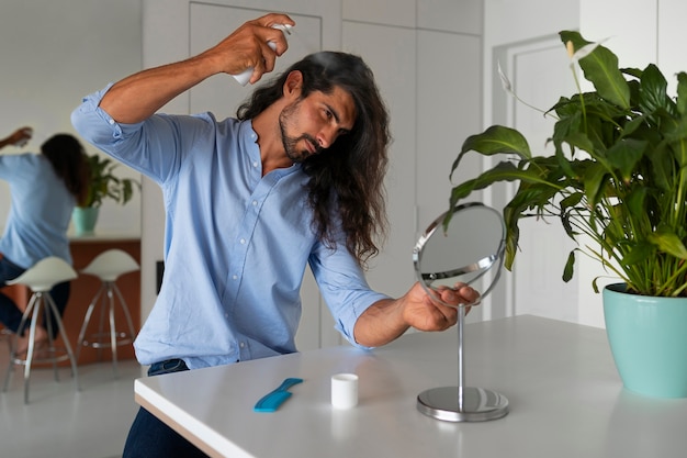 Foto gratuita hombre de tiro medio usando champú seco en casa