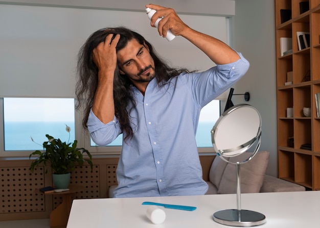 Foto gratuita hombre de tiro medio usando champú seco en casa