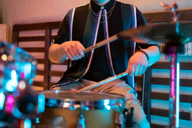 El hombre tocando la batería durante la actuación en un evento local.