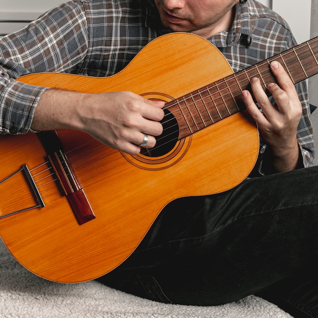 Hombre tocando la guitarra acústica antigua