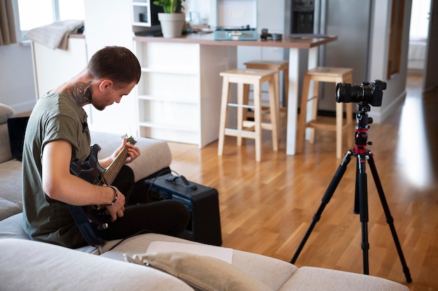 Foto gratuita hombre tocando la guitarra en casa