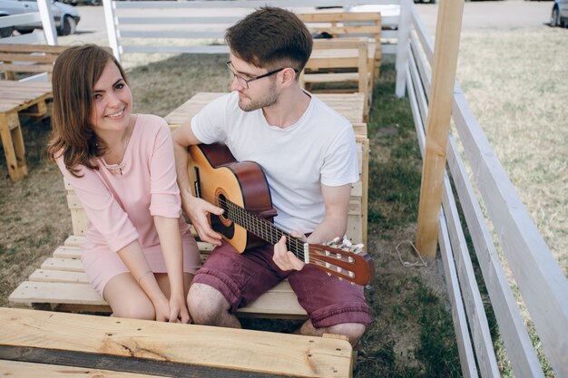 Hombre tocándo la guitarra para una chica joven