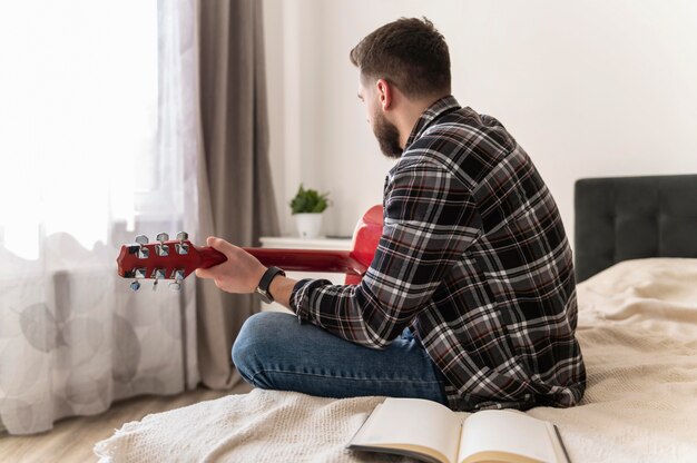 Hombre tocando la guitarra tiro medio