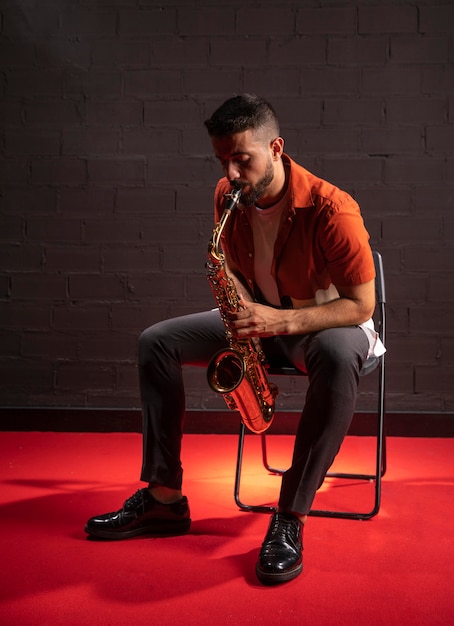 Hombre tocando el saxofón sentado