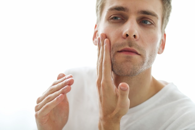 Hombre tocando su barba, listo para afeitarse.