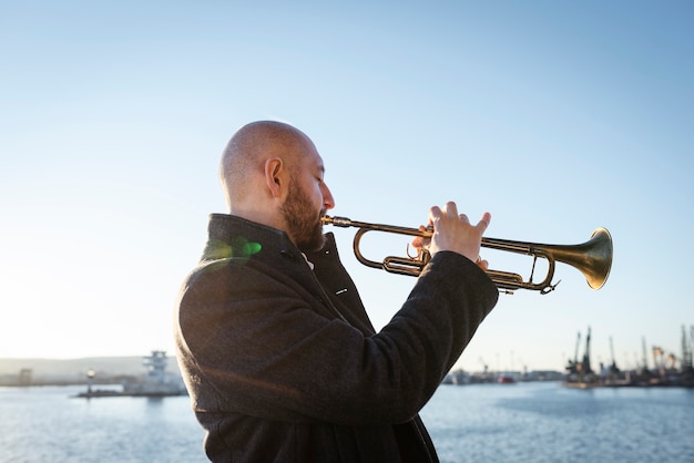 Foto gratuita hombre tocando la trompeta día internacional del jazz