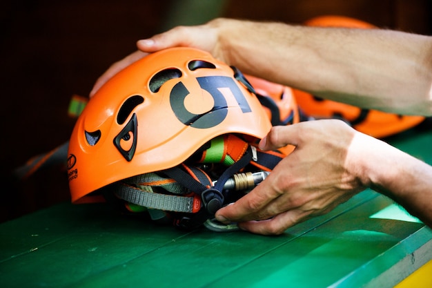 Foto gratuita el hombre toma un casco naranja con un número cinco