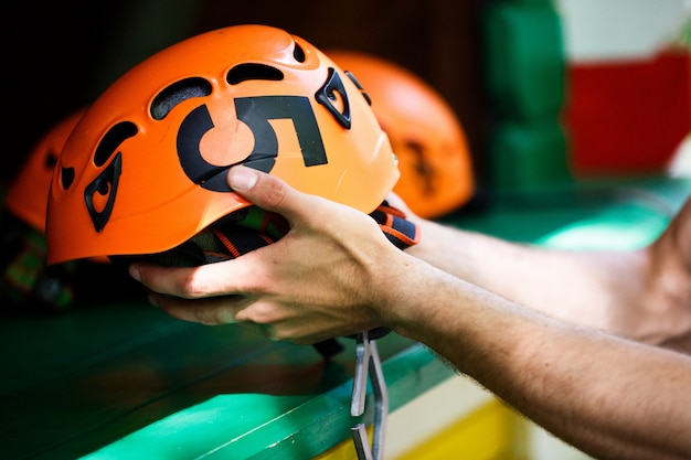 El hombre toma un casco naranja con un número cinco