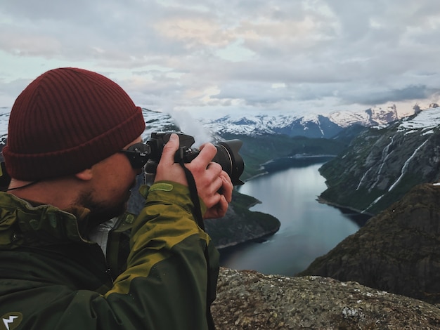 El hombre toma una imagen del paisaje escandinavo magnífico
