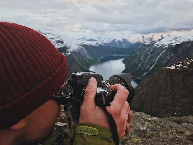 El hombre toma una imagen del paisaje escandinavo magnífico