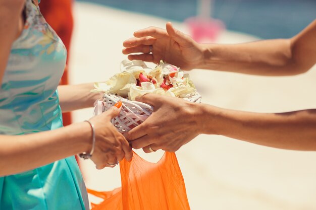 El hombre toma una palte con pétalos de las manos de la mujer