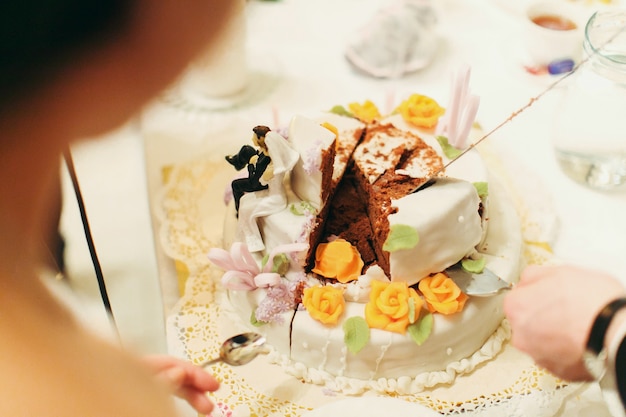 El hombre toma un pedazo de pastel de bodas