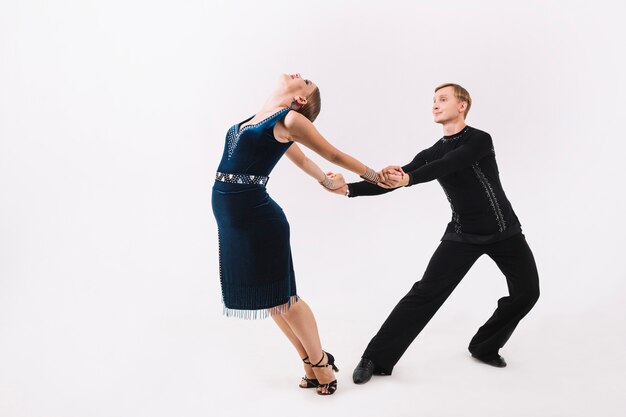 Hombre tomados de la mano de la mujer durante el baile