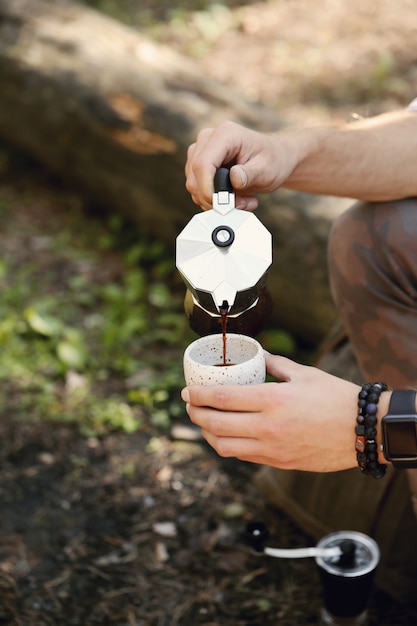 hombre tomando café en el bosque