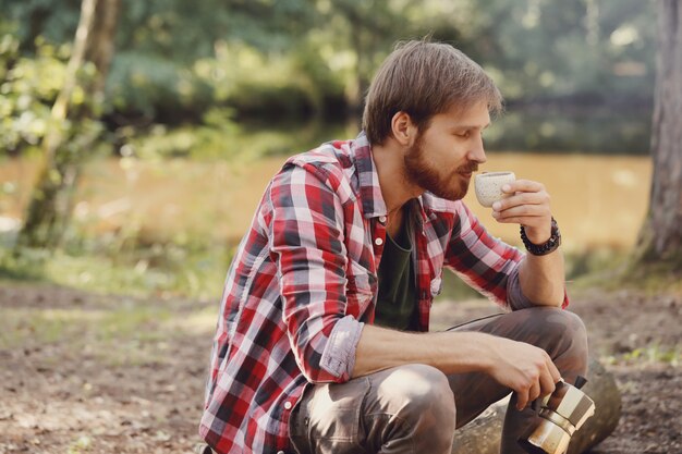 hombre tomando café en el bosque