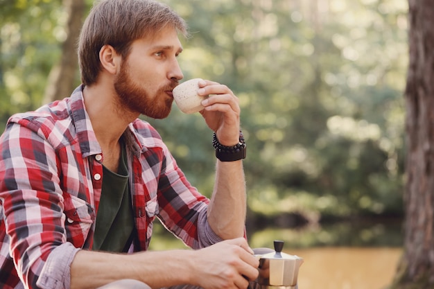 hombre tomando café en el bosque