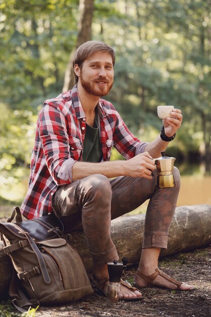 hombre tomando café en el bosque