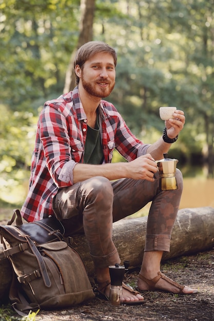 hombre tomando café en el bosque