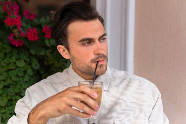 Hombre tomando un café helado al aire libre