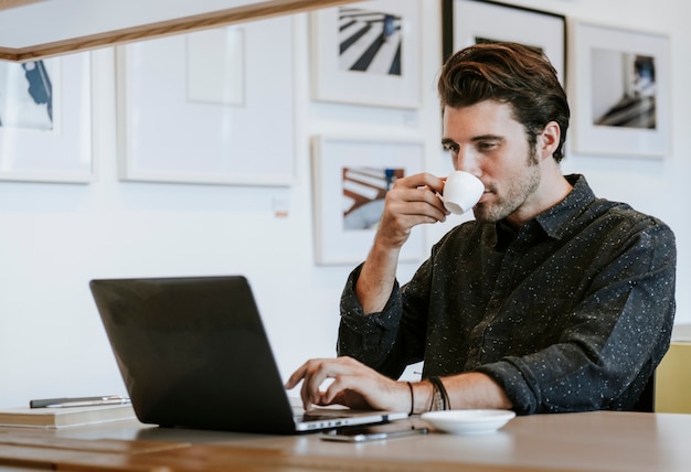 Hombre tomando un café mientras trabaja
