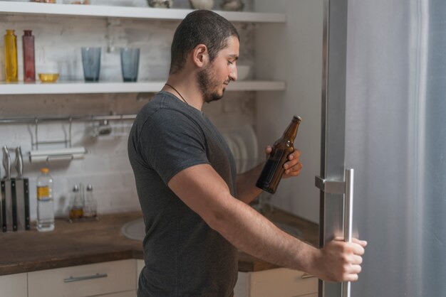 Hombre tomando cerveza de la nevera