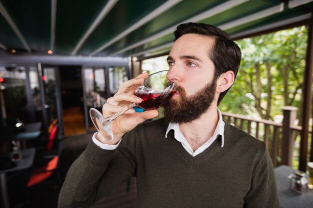 Hombre tomando una copa de vino en el bar