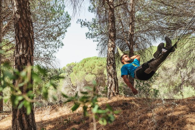 Hombre tomando un descanso en hamaca en bosque