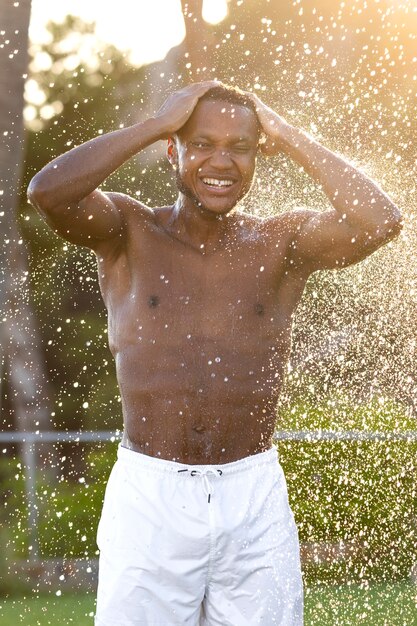 Hombre tomando ducha al aire libre vista frontal