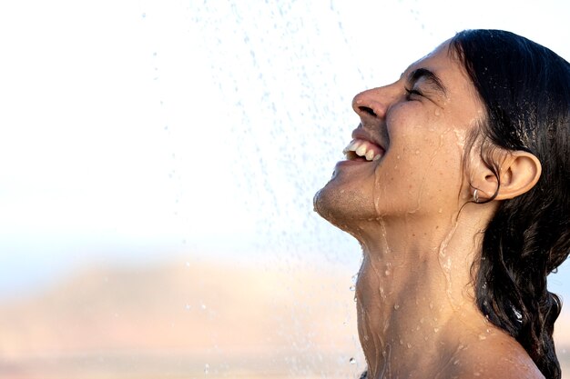 Foto gratuita hombre tomando ducha al aire libre vista lateral