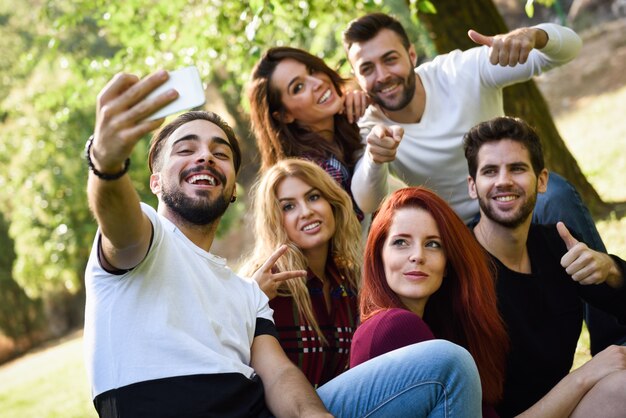 Hombre tomando una foto de él y sus amigos en el parque