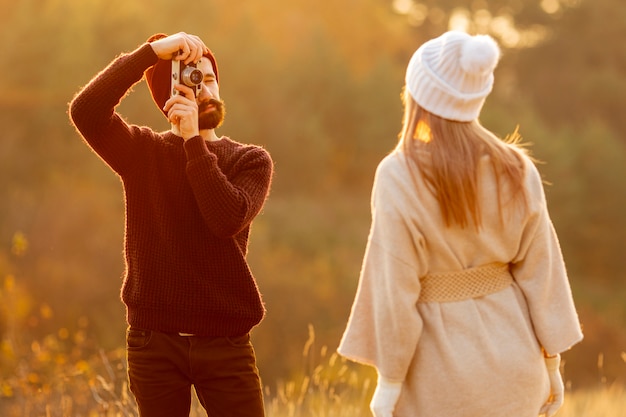 Hombre tomando una foto de su amigo afuera