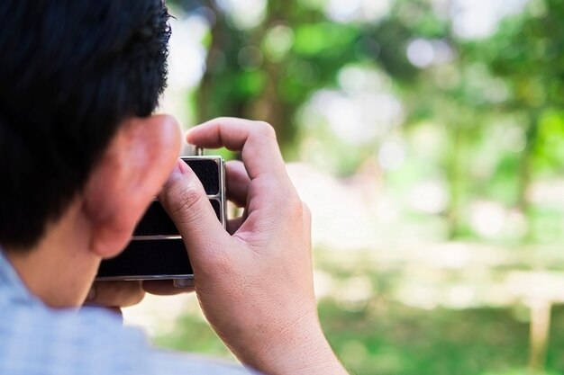 Hombre tomando foto usando vieja cámara retro