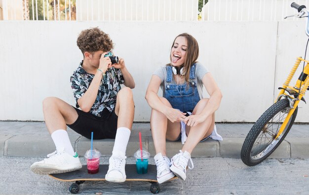 Hombre tomando fotografía de su novia con cámara