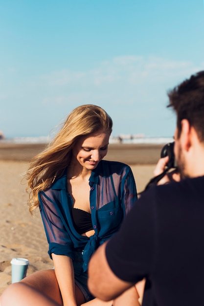 Foto gratuita hombre tomando fotos de mujer en la playa