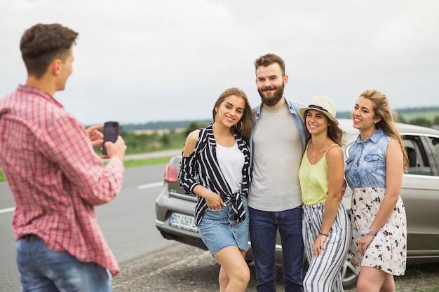 Hombre tomando fotos de sus amigos en la carretera