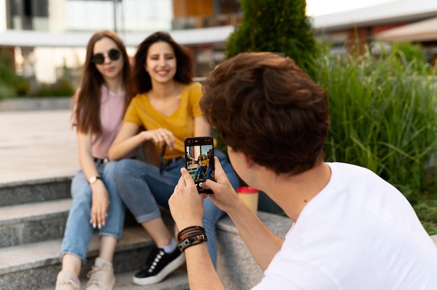 El hombre tomando fotos de sus amigos mientras está al aire libre