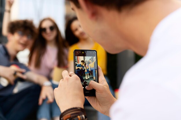 El hombre tomando fotos de sus amigos mientras está al aire libre