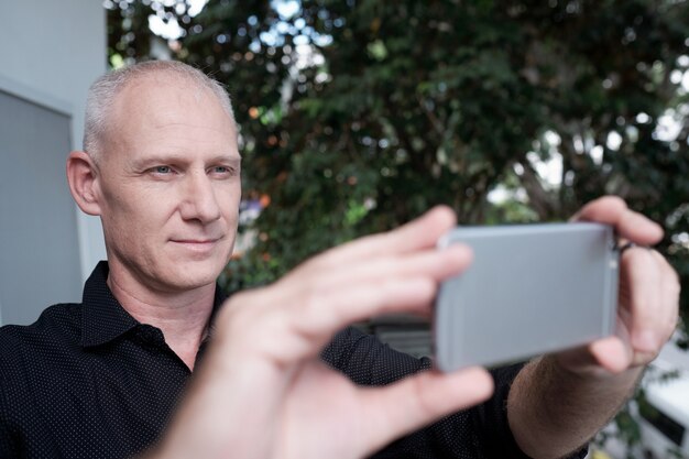 Hombre tomando fotos en el teléfono inteligente