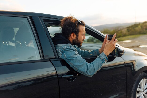 Hombre tomando fotos en el teléfono en viaje