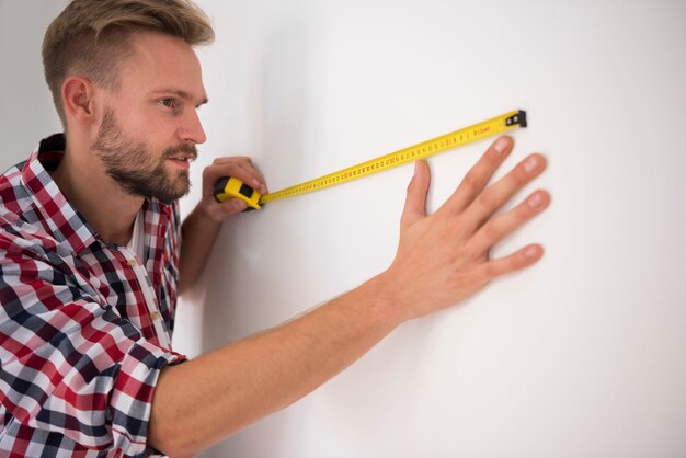 Hombre tomando medidas en el futuro salón