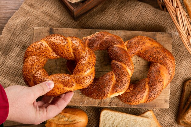 Hombre tomando sabroso bagel de tablero de cocina