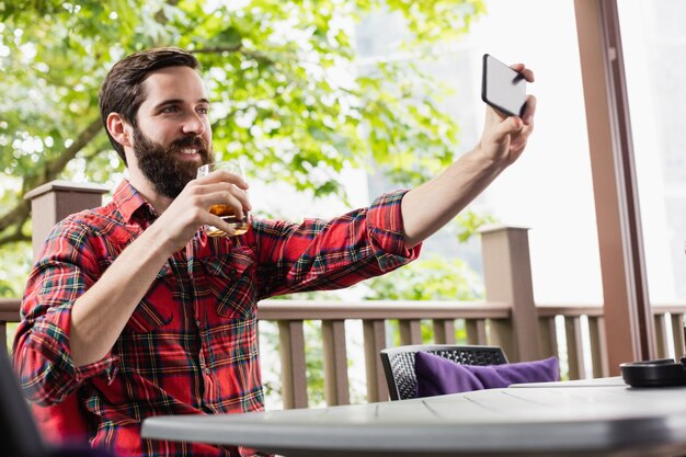 Hombre tomando una selfie mientras bebe