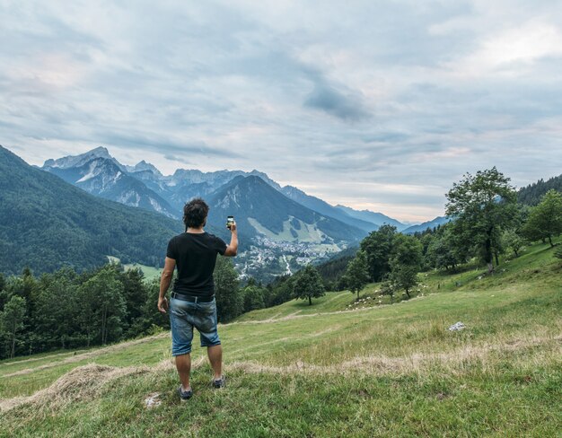 Hombre tomando selfie en paisaje de montañas