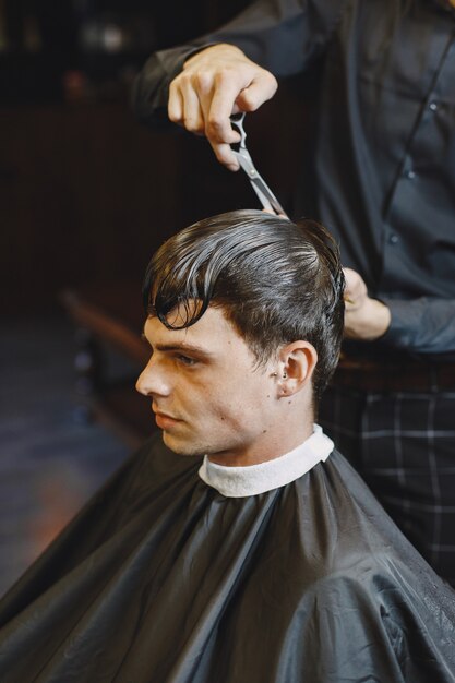 Foto gratuita el hombre trabaja con el cabello. peluquería con cliente.