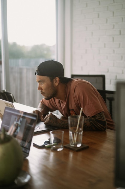 Un hombre trabaja en una computadora en un espacio de coworking. Trabajo remoto, espacio de trabajo.