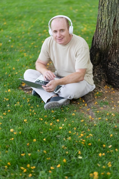 Foto gratuita un hombre trabaja en una computadora portátil en el parque