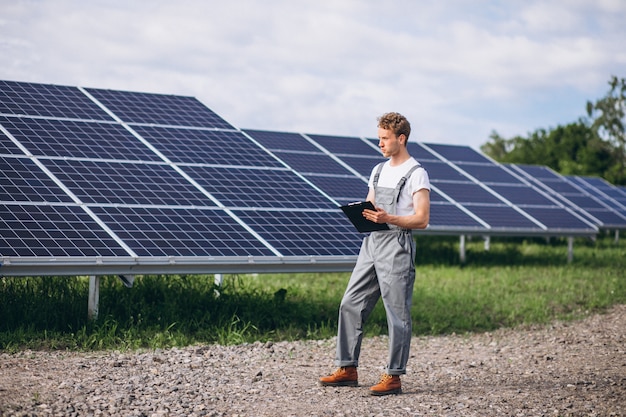 Foto gratuita hombre trabajador en el campo junto a los paneles solares.