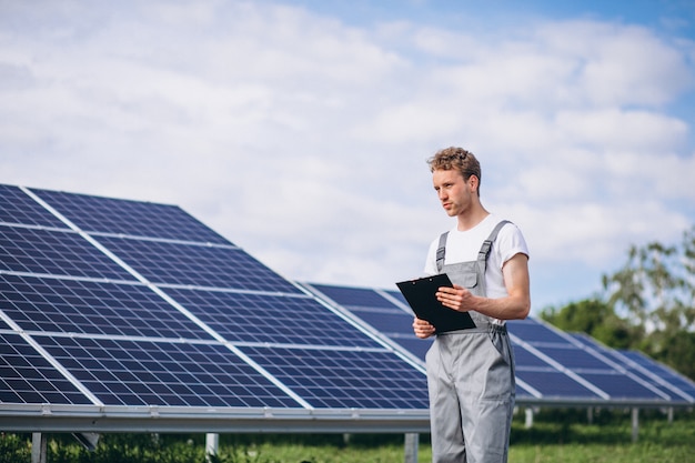 Hombre trabajador en el campo junto a los paneles solares.